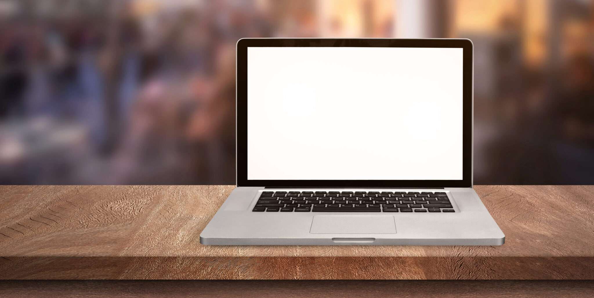 木製のテーブルの上に空白の画面を持つラップトップ コンピューター。
