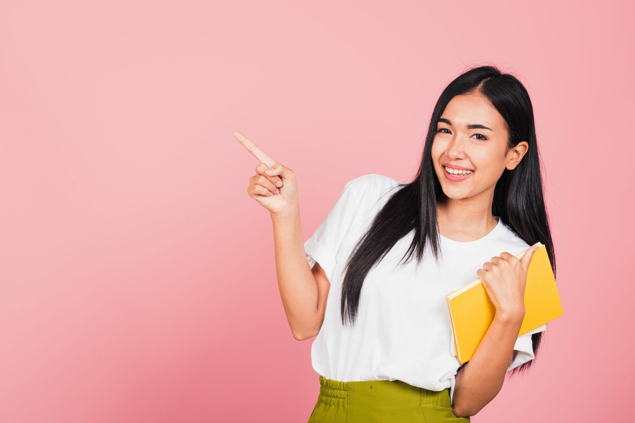 黄色のフォルダーを持ち、側面を指差す女性。