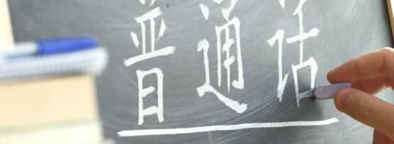 中国で黒板に漢字を書く人。