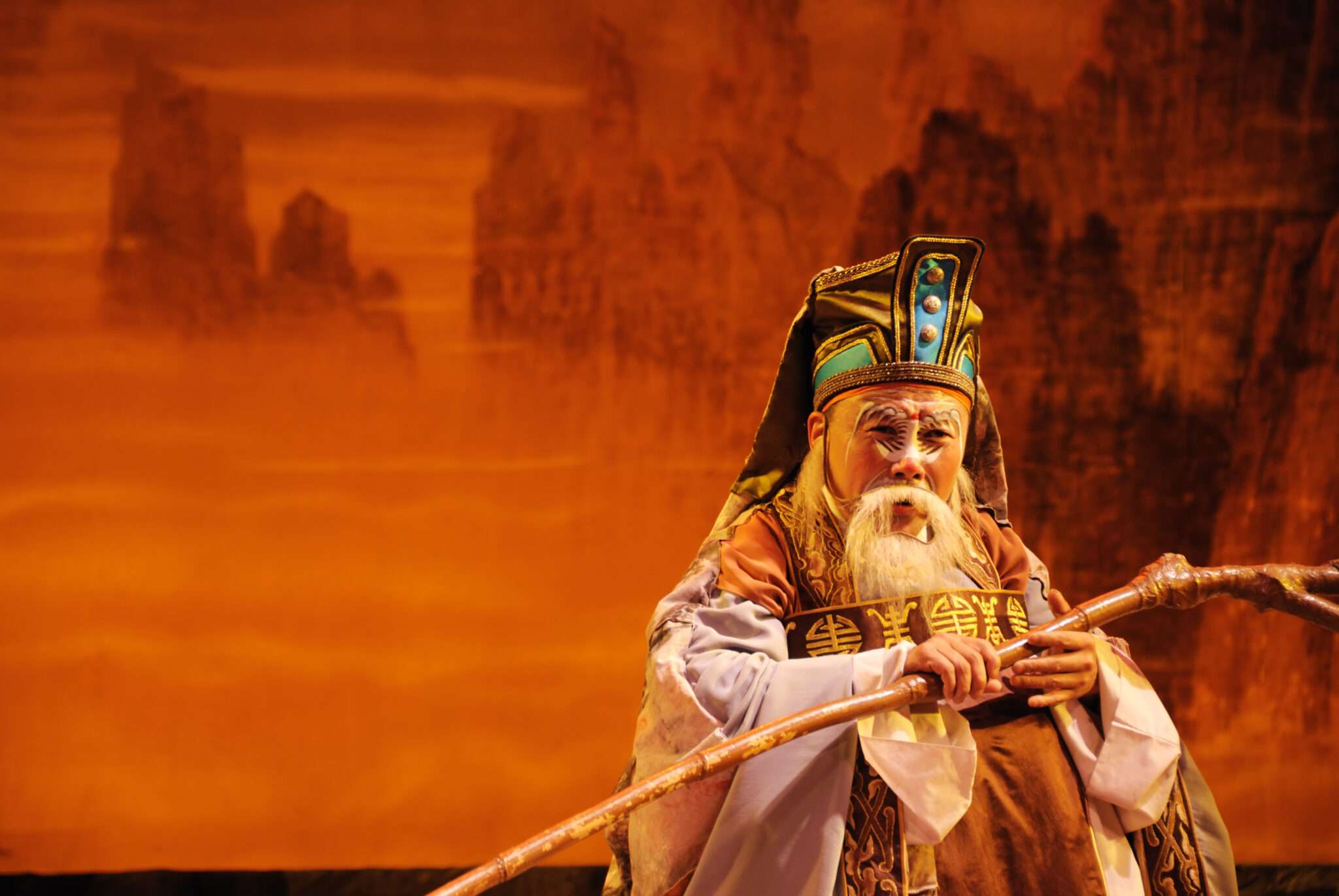 棒を持った中国衣装を着た中国の男性。