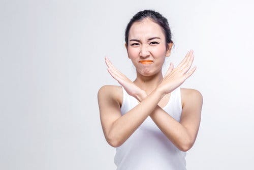 中国の白い背景にニンジンで顔を作るアジアの女性。