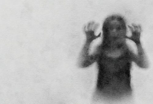 中国の伝統衣装を着て手を上げている女性の白黒写真。