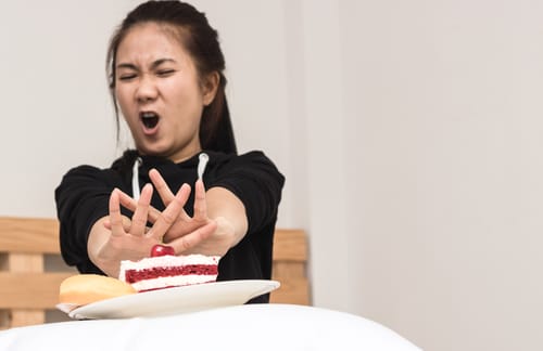 中国で女性が顔の前にケーキを持っている。 中国で女性が顔の前にケーキを持っている。