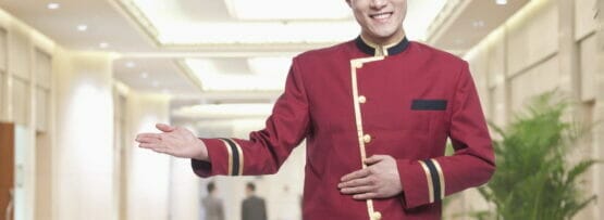 中国の廊下に立つ赤い制服を着た男性。