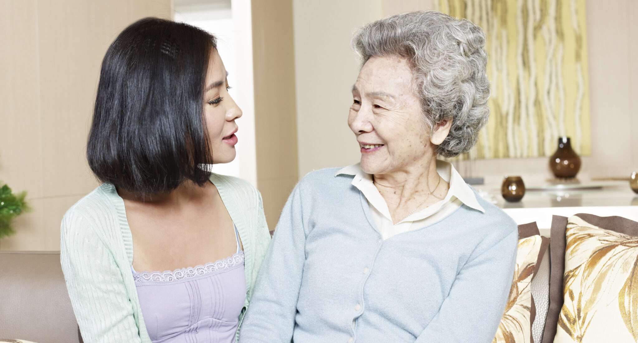 ソファで年配の中国人女性と話す女性。