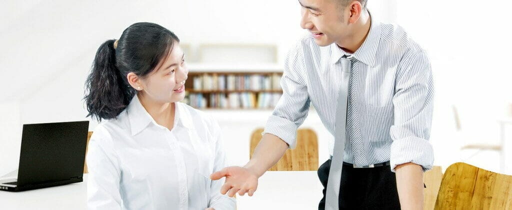 テーブルで握手する男性と女性。