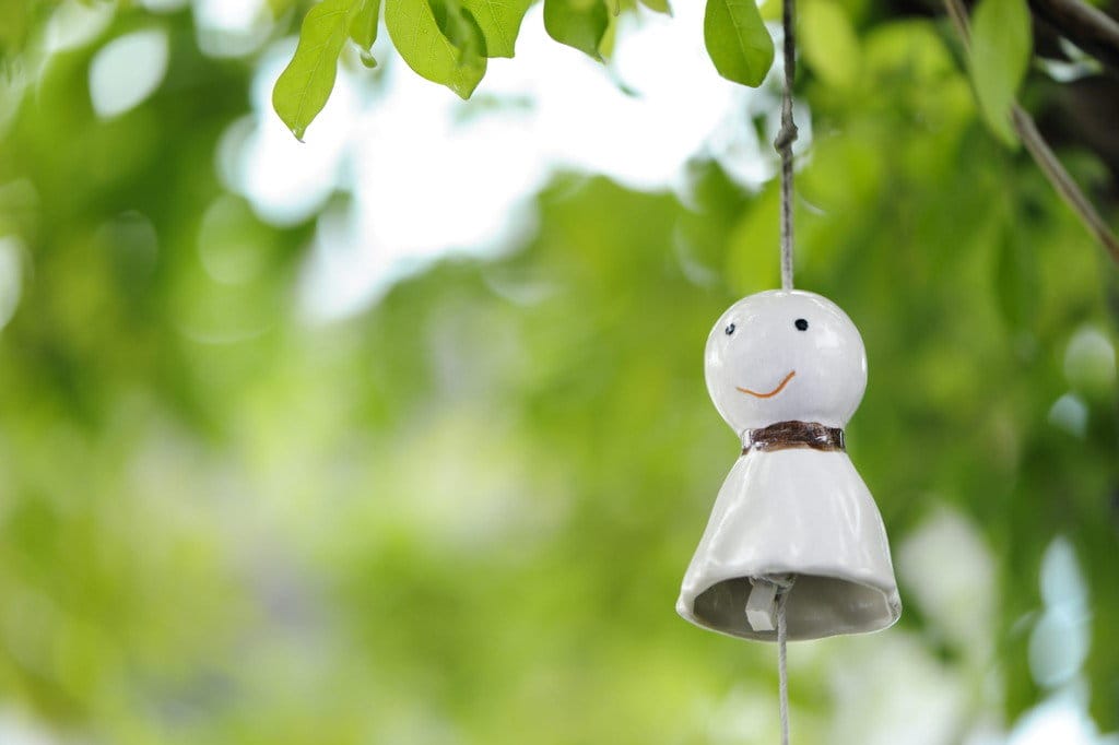 木からぶら下がっている陶器の中国の置物。