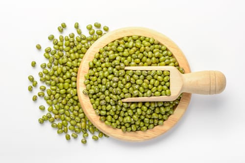 中国の白い背景に木のスプーンにグリーンピース。 中国の白い背景に木のスプーンにグリーンピース。