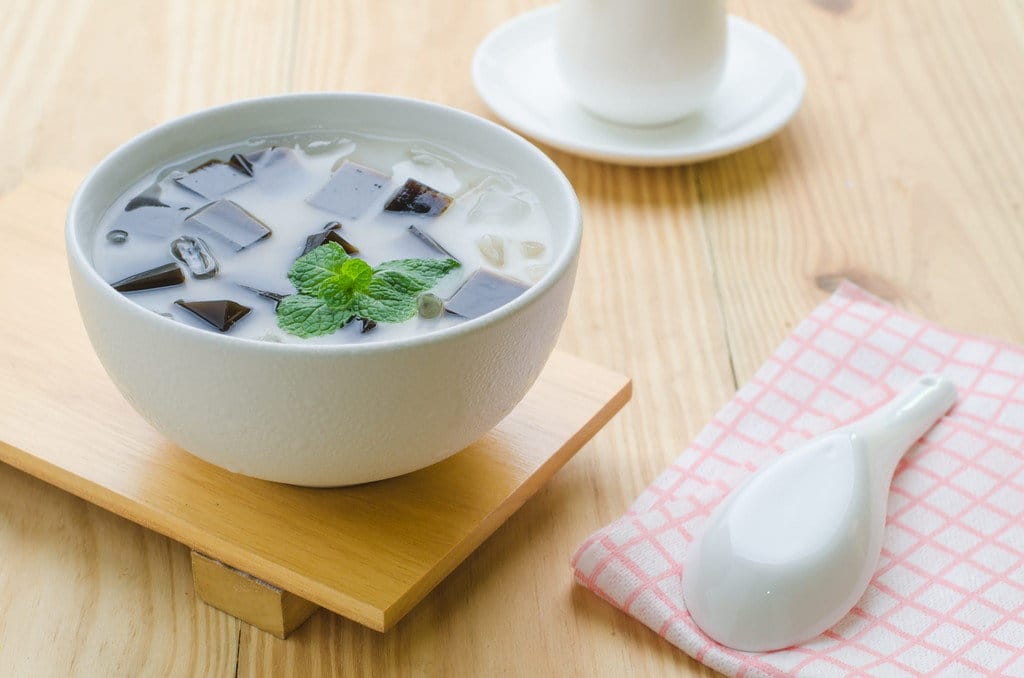 木のテーブルの上に白いカップに入った中国からの日本のアイスティー。