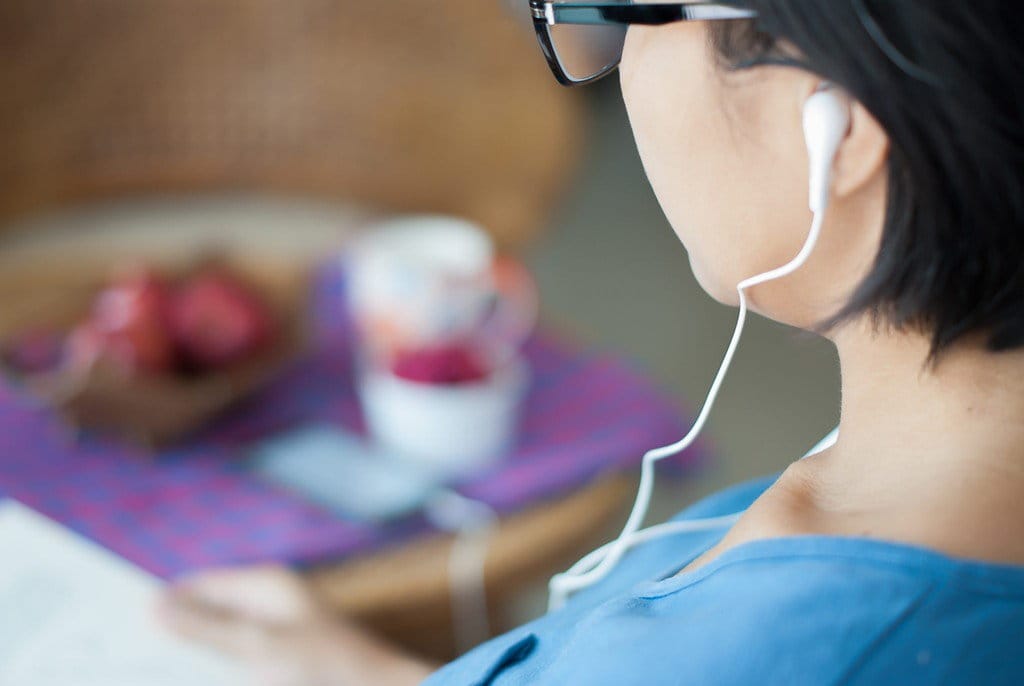 中国でイヤホンをして本を読む女性。