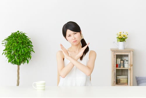 中国の鉢植えの前で身振り手振りをするアジア系の若い女性。 中国の鉢植えの前で身振り手振りをするアジア系の若い女性。