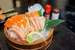 テーブルの上の木製バスケットに入った日本の刺身。 テーブルの上の木製バスケットに入った日本の刺身。