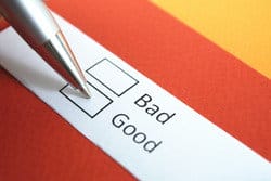 「悪い」と「良い」という言葉が書かれた紙の上にペンが置かれます。 「悪い」と「良い」という言葉が書かれた紙の上にペンが置かれます。