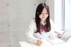 机に座って本を読んでいる中国人の女の子。 机に座って本を読んでいる中国人の女の子。