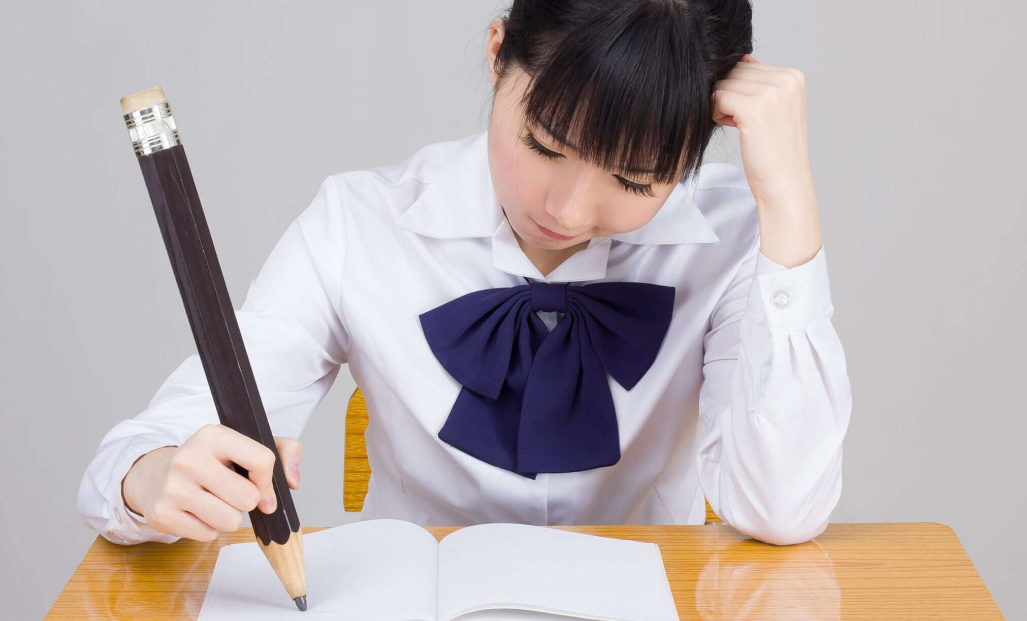 一人は中国の学校の制服を着た女子生徒用の铅笔文字を書いた。