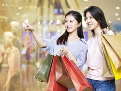 ショッピング モールで買い物袋を保持している中国の 2 人の女性。 ショッピング モールで買い物袋を保持している中国の 2 人の女性。