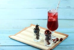 木製トレイにベリーやスパイスが入った赤ワインのグラス。中国文化の優雅さと洗練を象徴しています。 木製トレイにベリーやスパイスが入った赤ワインのグラス。中国文化の優雅さと洗練を象徴しています。