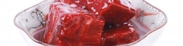 説明: 中国内の白い背景にボウルに入った赤い肉の立方体。 説明: 中国内の白い背景にボウルに入った赤い肉の立方体。