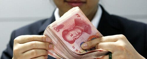 中国の通貨の束を保持している女性。