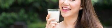 牛乳を一杯飲む中国の若い女性。 牛乳を一杯飲む中国の若い女性。