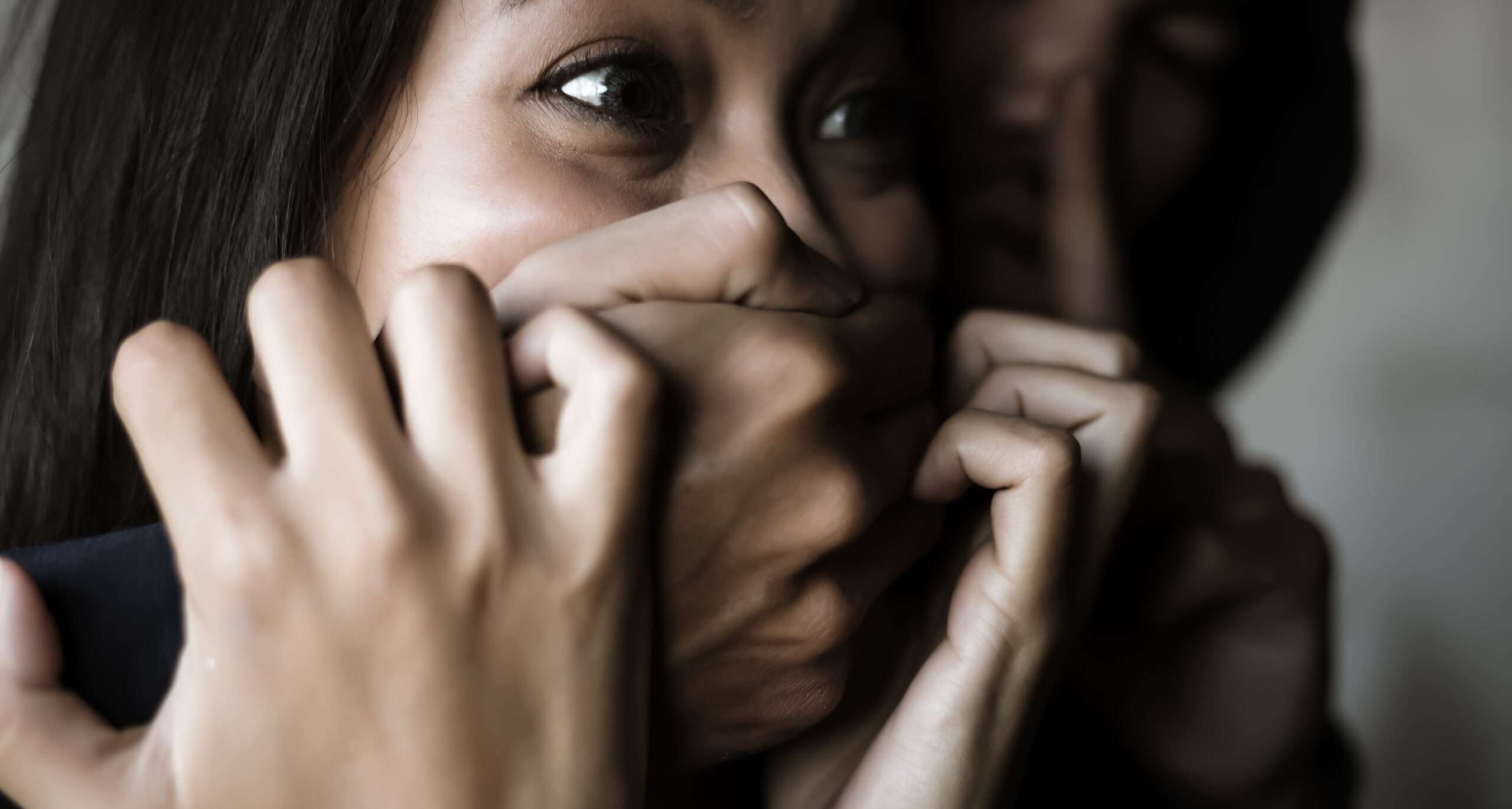 中国で女性が手で顔を覆っている。