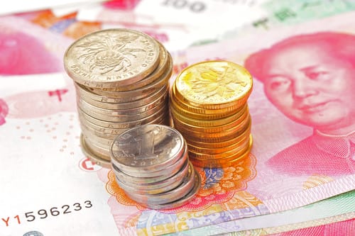 中国の紙幣の上に中国のコインが積み重なっています。 中国の紙幣の上に中国のコインが積み重なっています。