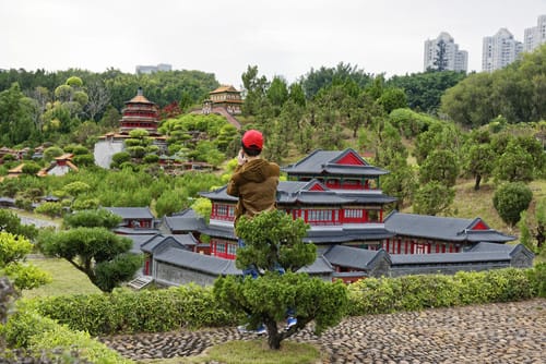 説明: 一人の人が中国村庄の模型を観察中。