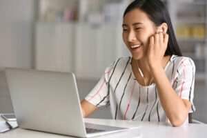 ラップトップで音楽を聴いている若い中国人女性。 ラップトップで音楽を聴いている若い中国人女性。