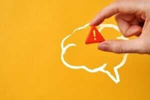 片方の手は、黄色の背景の上に、ある色の演奏の泡を持っています。 片方の手は、黄色の背景の上に、ある色の演奏の泡を持っています。