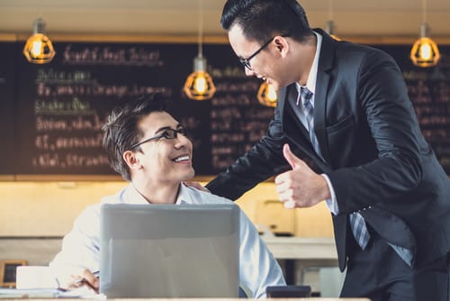 中国のコーヒー ショップで親指を立てる 2 人のビジネスマン。 中国のコーヒー ショップで親指を立てる 2 人のビジネスマン。