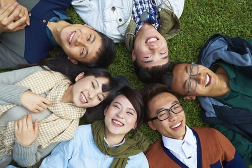 芝生の上に横たわる若者のグループ。