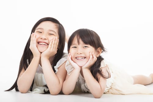 白い背景に横たわる 2 人の中国人の女の子。