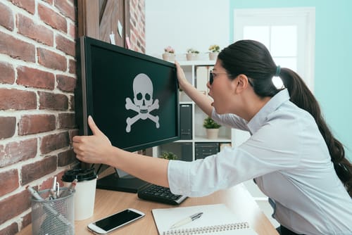 中国滞在中に、どくろが描かれたコンピューター画面を見ている女性。