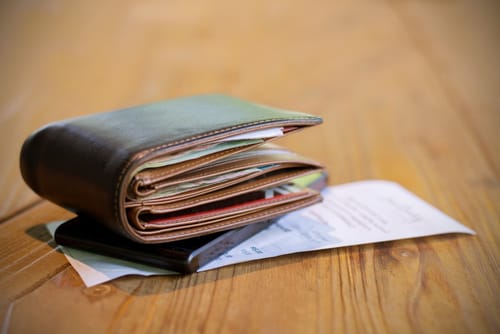 中国の木のテーブルの上にお札が置かれた財布。