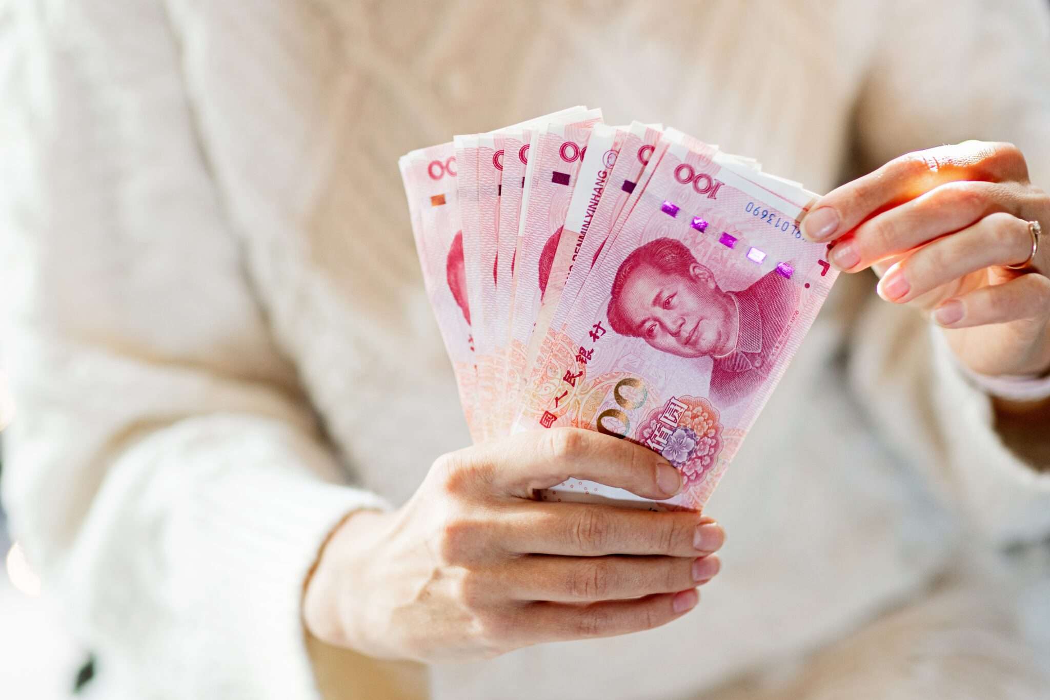 中国の通貨の束を保持している女性。