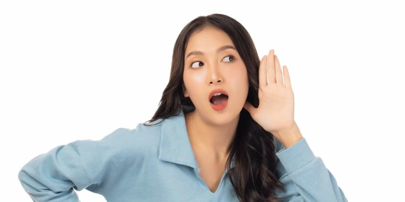 中国から来た若いアジア人女性が手で大きな音を立てている。