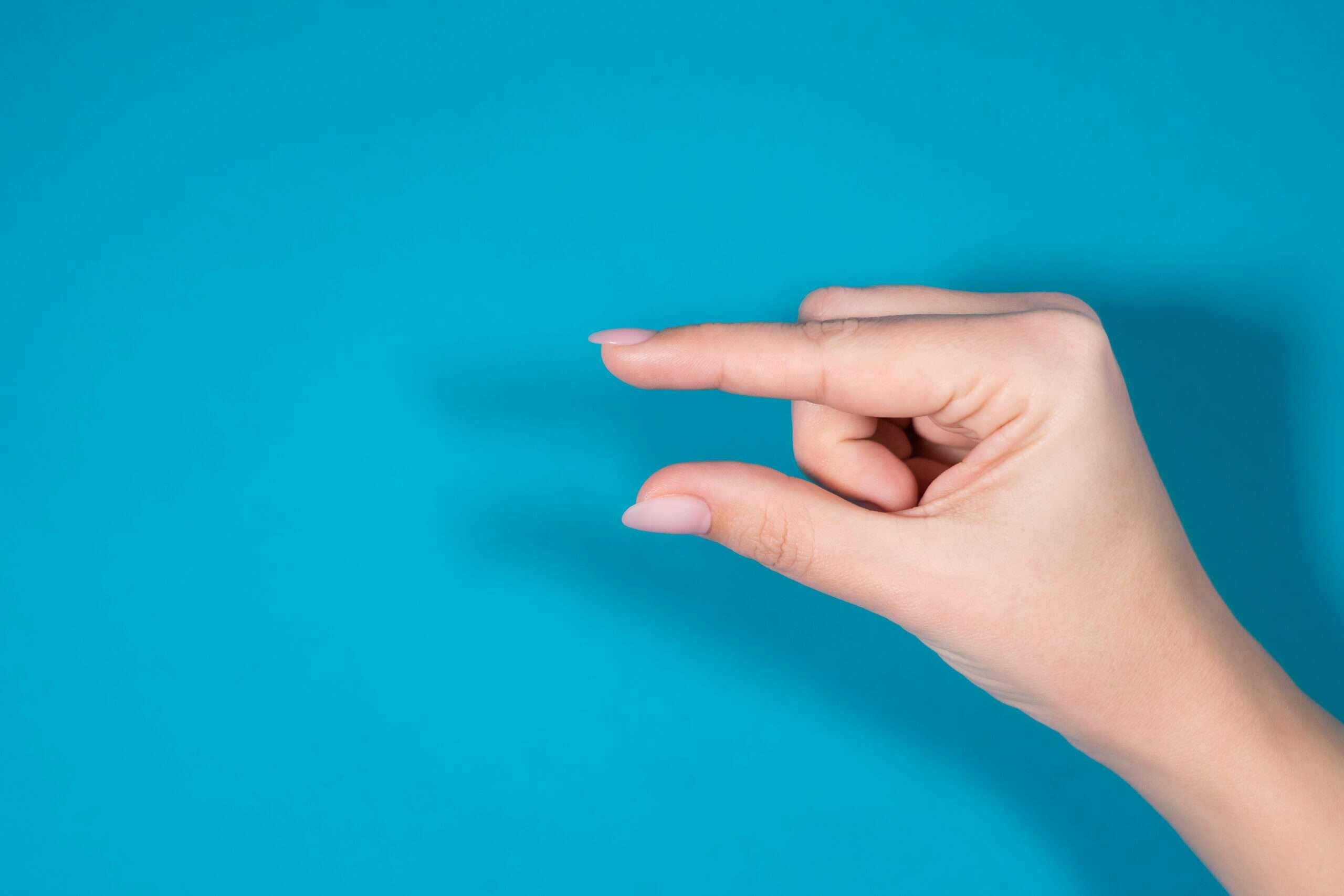 中国の青い背景に女性の手が何かを指している。