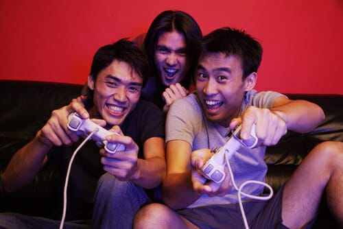 中国のソファでビデオゲームをする 3 人の男性。