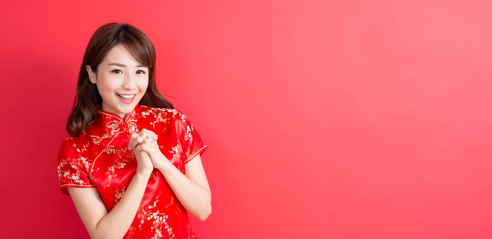 赤いドレスを着て写真にポーズをとる中国の女性。