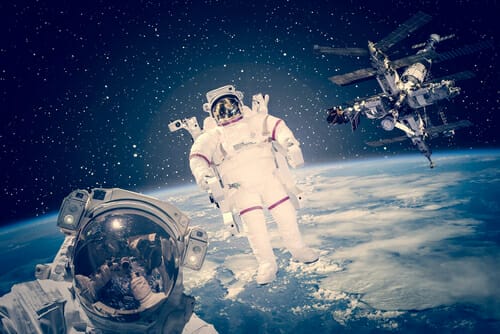 NASA から提供された背景要素で地球とともに宇宙に浮かぶ宇宙飛行士。