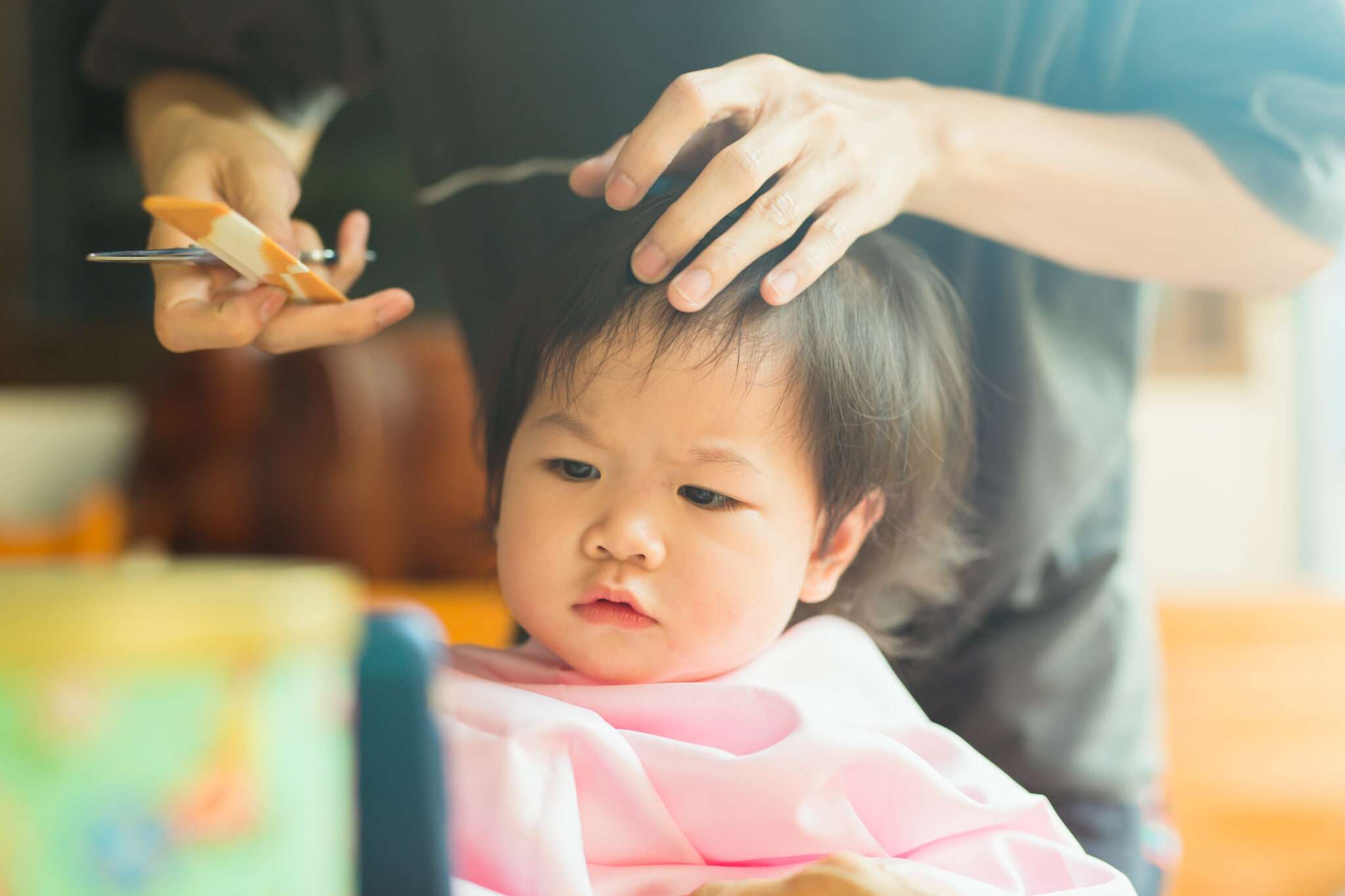 子供の髪を切る中国の男性。