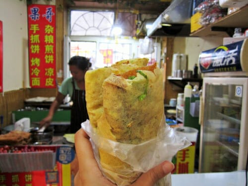 中国のレストランでサンドイッチを手に持つ人。