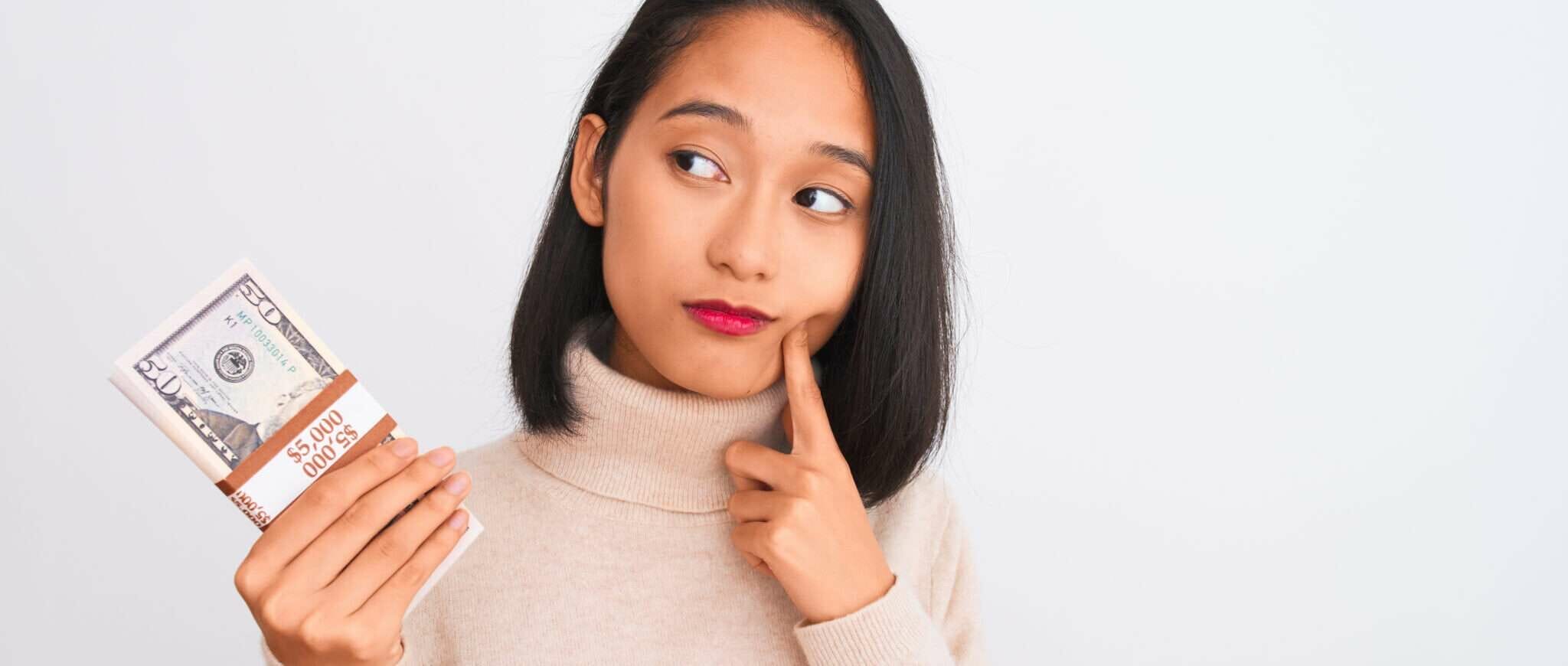 手にドル紙幣を持つ中国の若い女性。