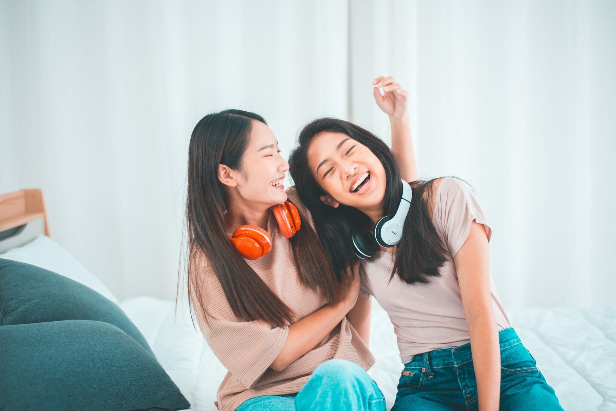 Two,Young,Asian,Women,Listening,To,Music,In,The,Living