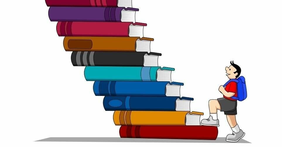 中国で少年が本の山の上に立っている。