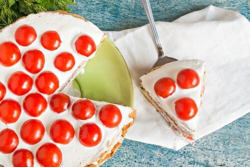 皿にトマトが入ったおいしいチーズケーキのスライス。 皿にトマトが入ったおいしいチーズケーキのスライス。