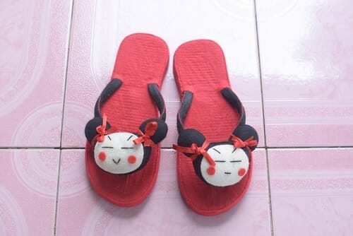 中国から来た、黒猫が描かれた赤いビーチサンダル。