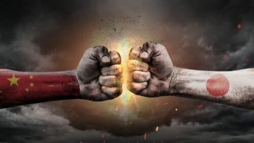 日本と中国の国旗を誇らしげに握る二つの拳。 日本と中国の国旗を誇らしげに握る二つの拳。