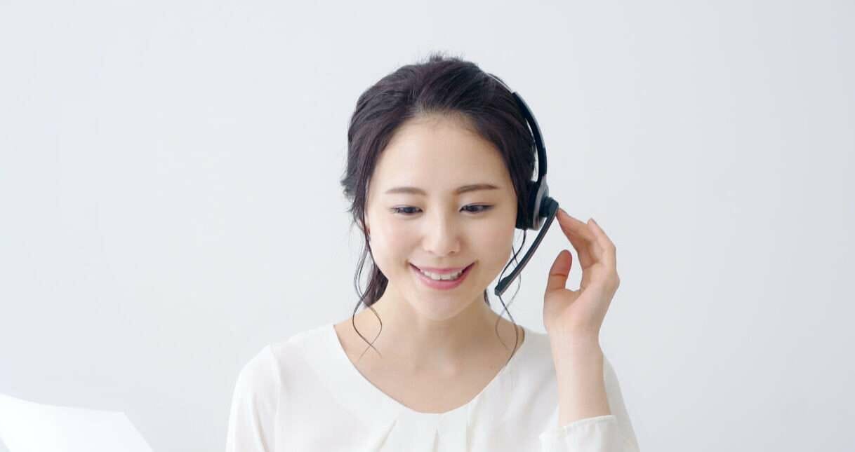 ヘッドセットを着けて微笑む中国の女性。