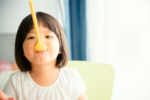 中国で黄色いスプーンを口にくわえた少女。 中国で黄色いスプーンを口にくわえた少女。